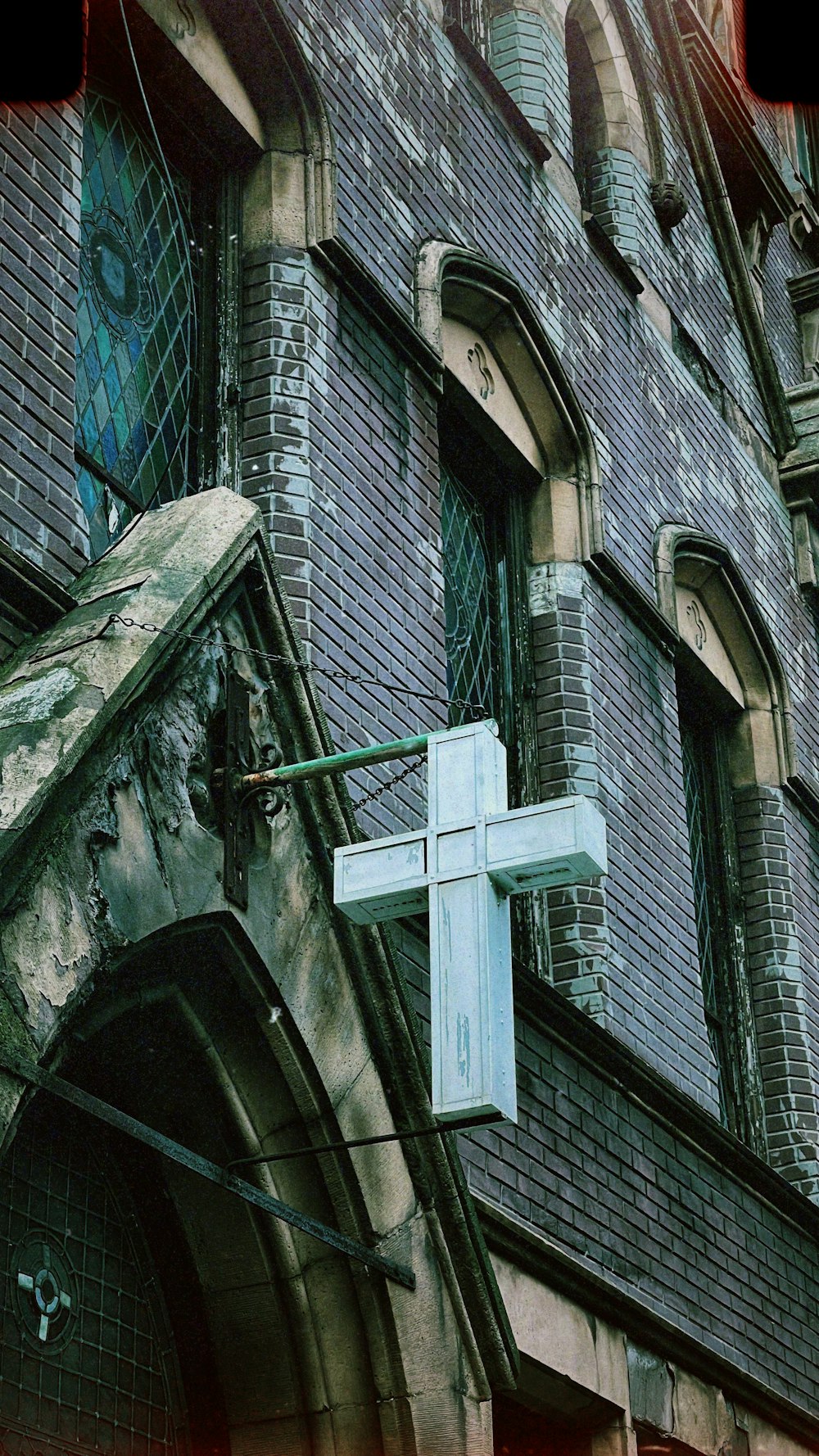 a large white cross hanging from the side of a building