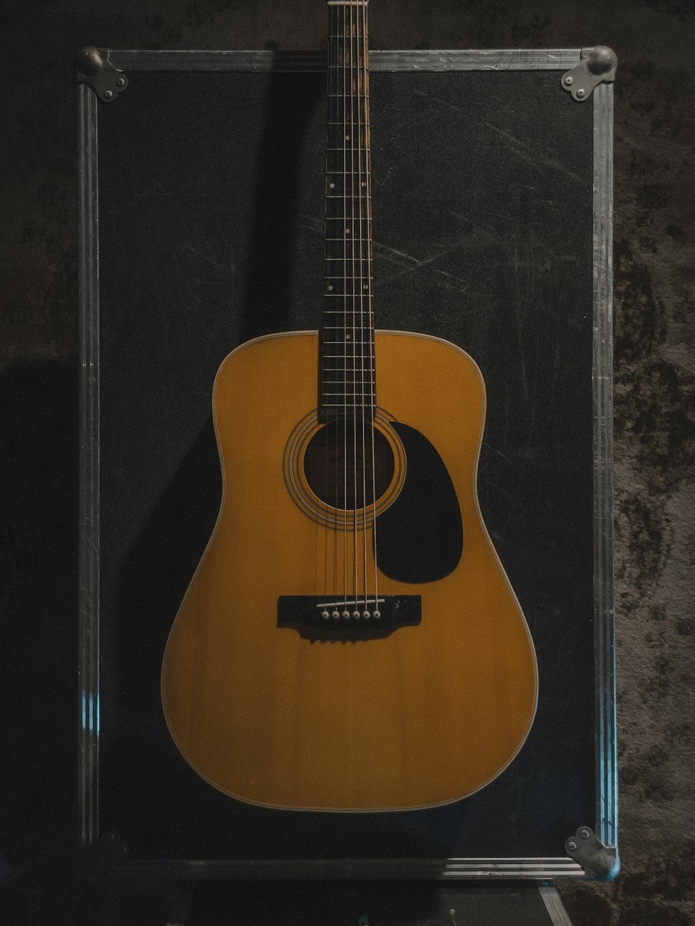 an acoustic guitar in a case on a wall