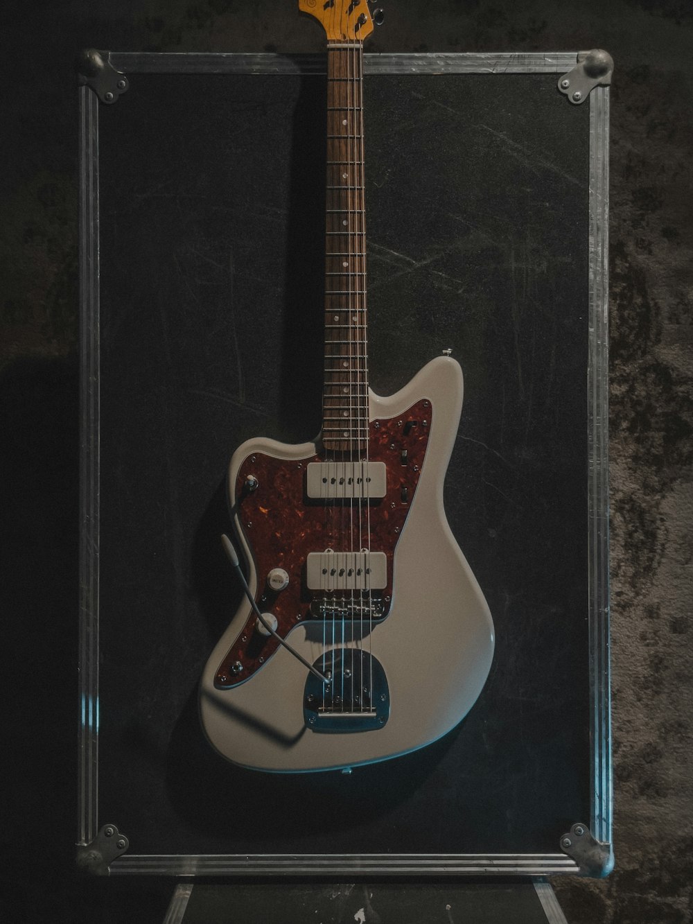 a white guitar is in a clear case