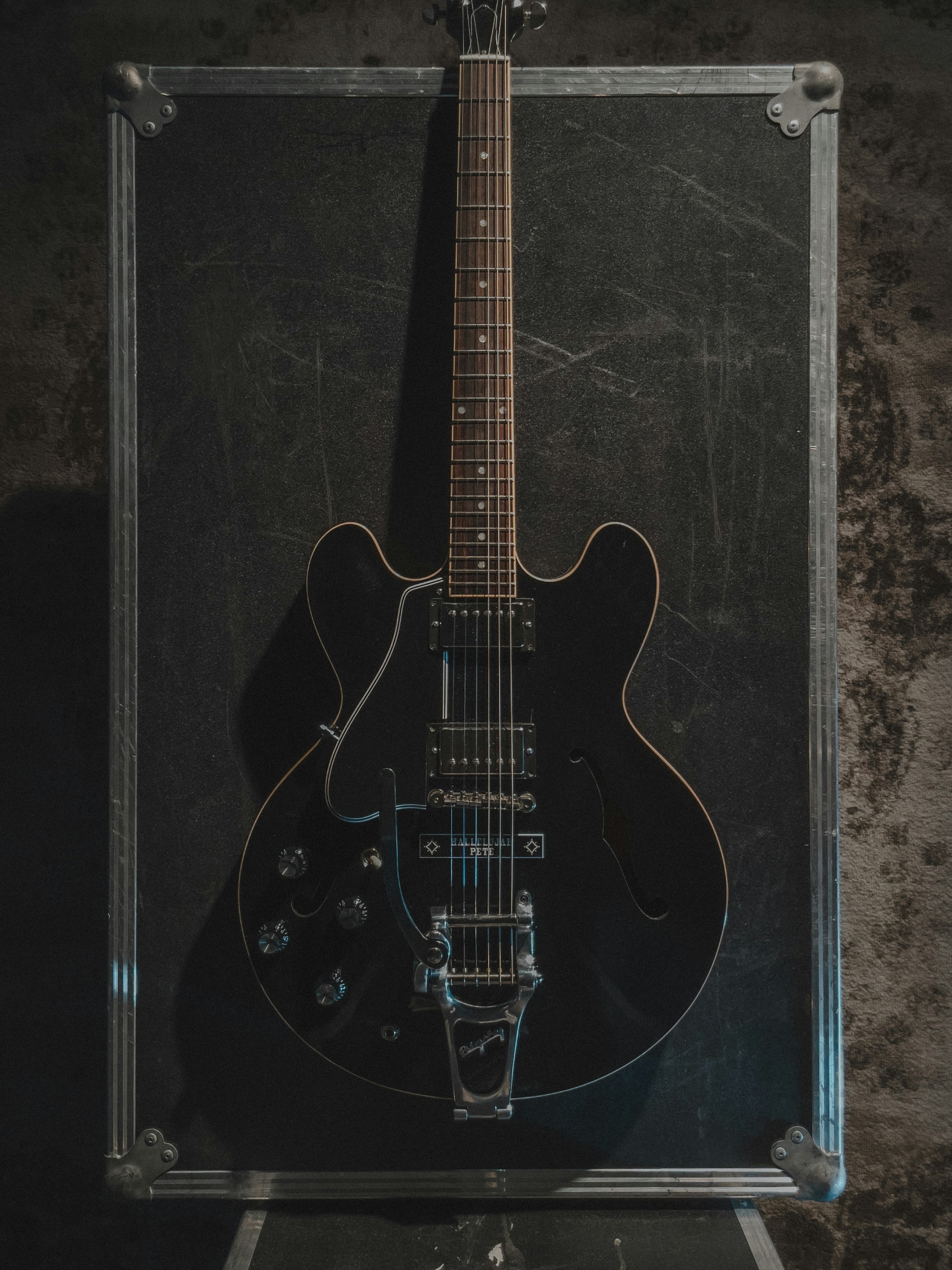 a black guitar is in a clear case