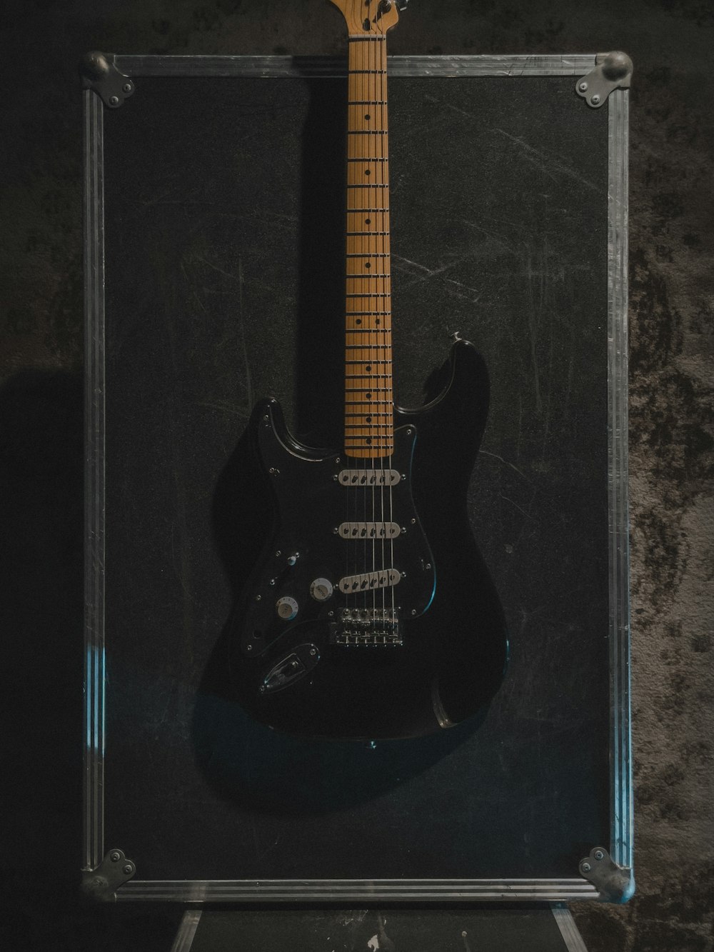 a black electric guitar sitting in a case