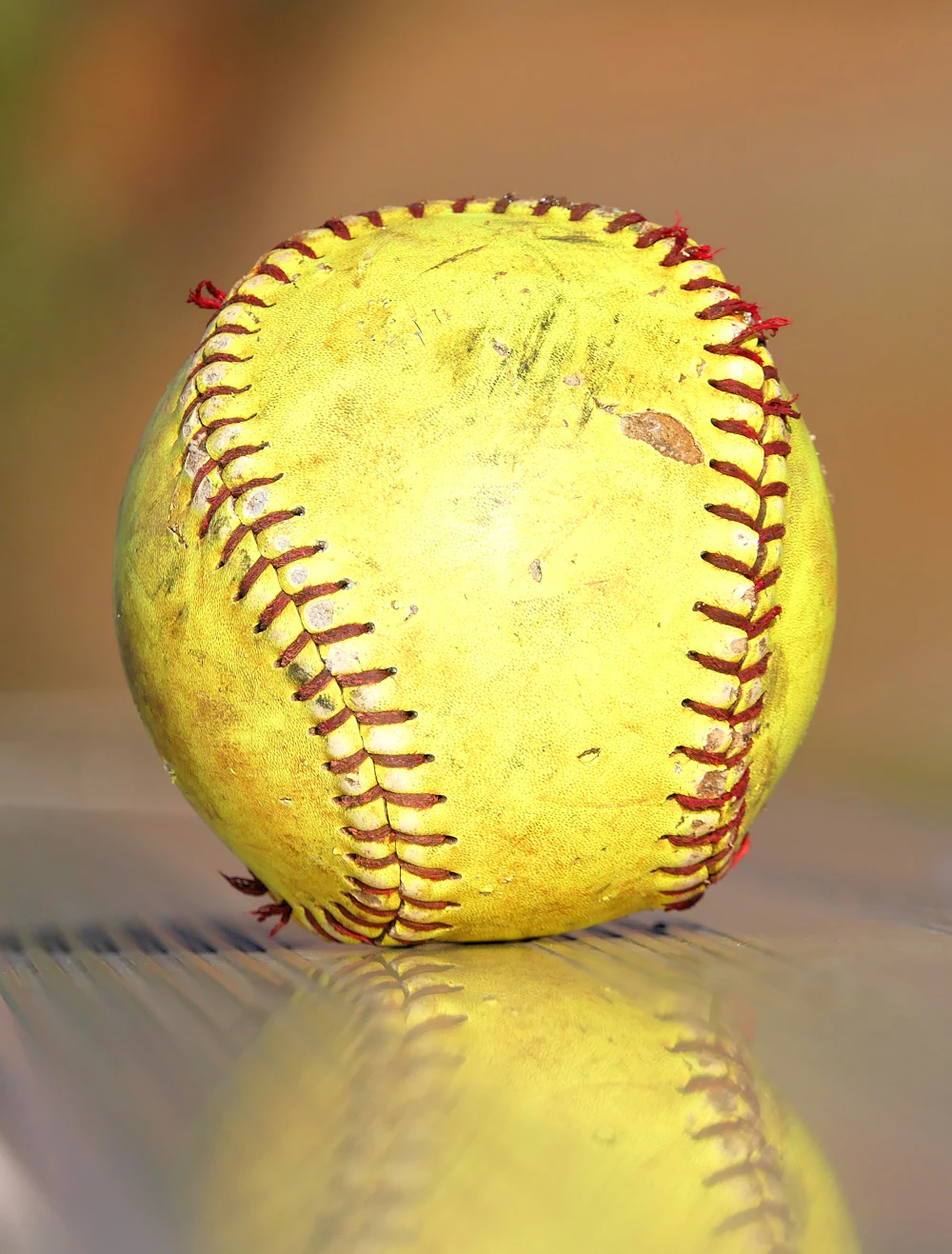 A worn yellow softball, close up