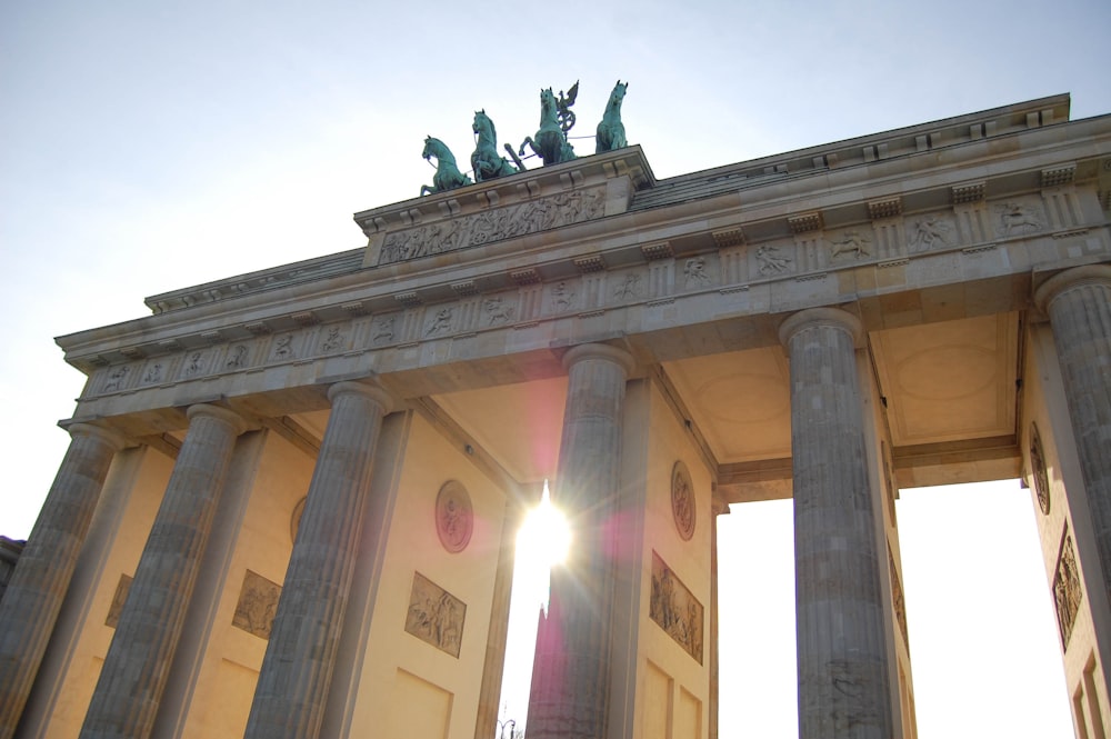 the sun shines through the arch of a building