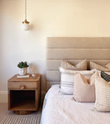 A cozy bedroom scene featuring a bed layered with various Dreamnest pillows and matching cases.