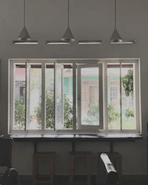 a room with three windows and a piano