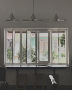 a room with three windows and a piano