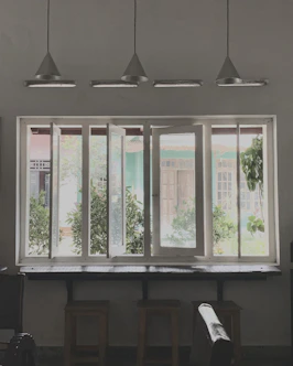 a room with three windows and a piano
