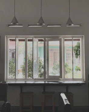 a room with three windows and a piano