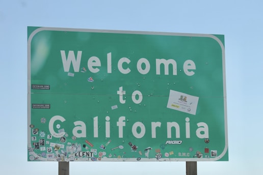 a welcome to california sign with stickers on it