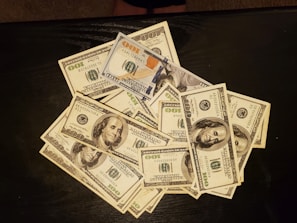 a pile of twenty dollar bills sitting on top of a table