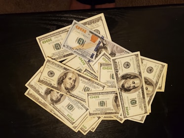 a pile of twenty dollar bills sitting on top of a table