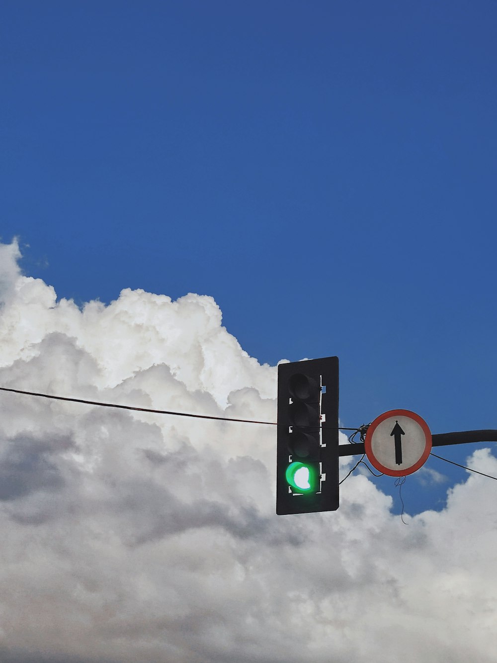 a green traffic light hanging from a wire
