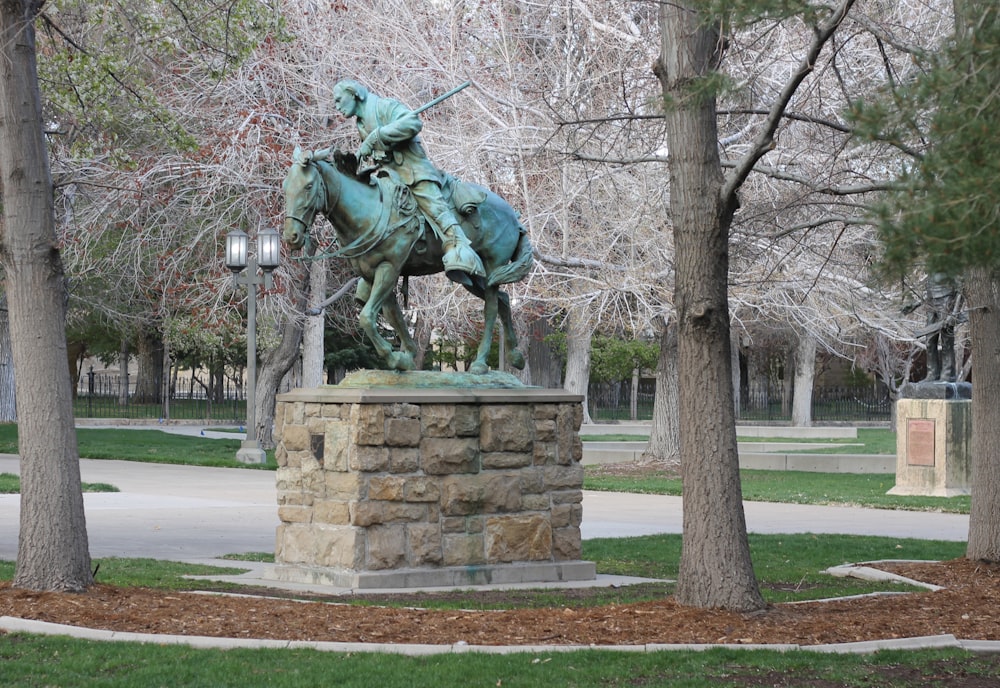 uma estátua de um homem em um cavalo em um parque