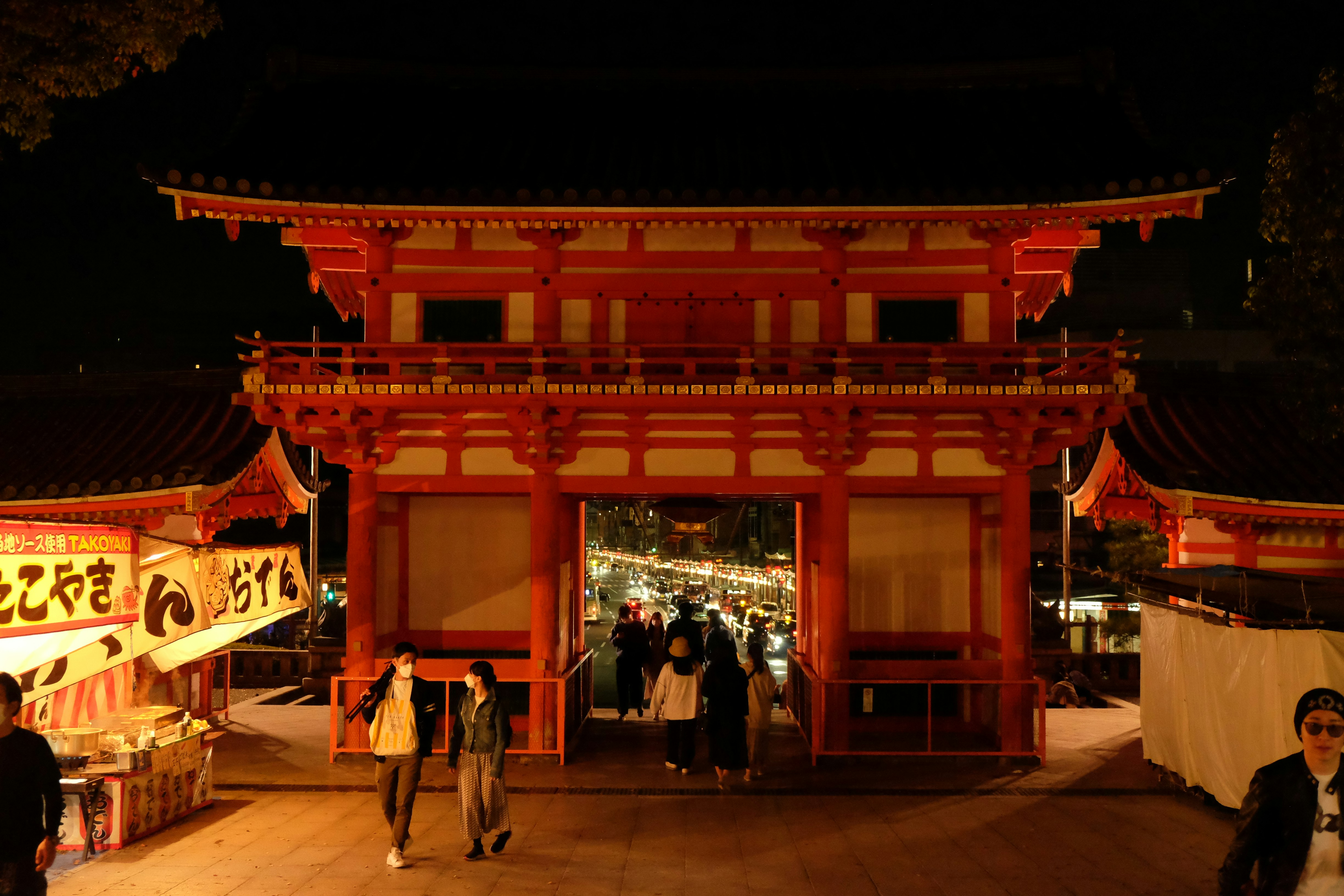 Large crowd of people walking towards a Japanese shrine gate (torii) at night for Hatsumōde