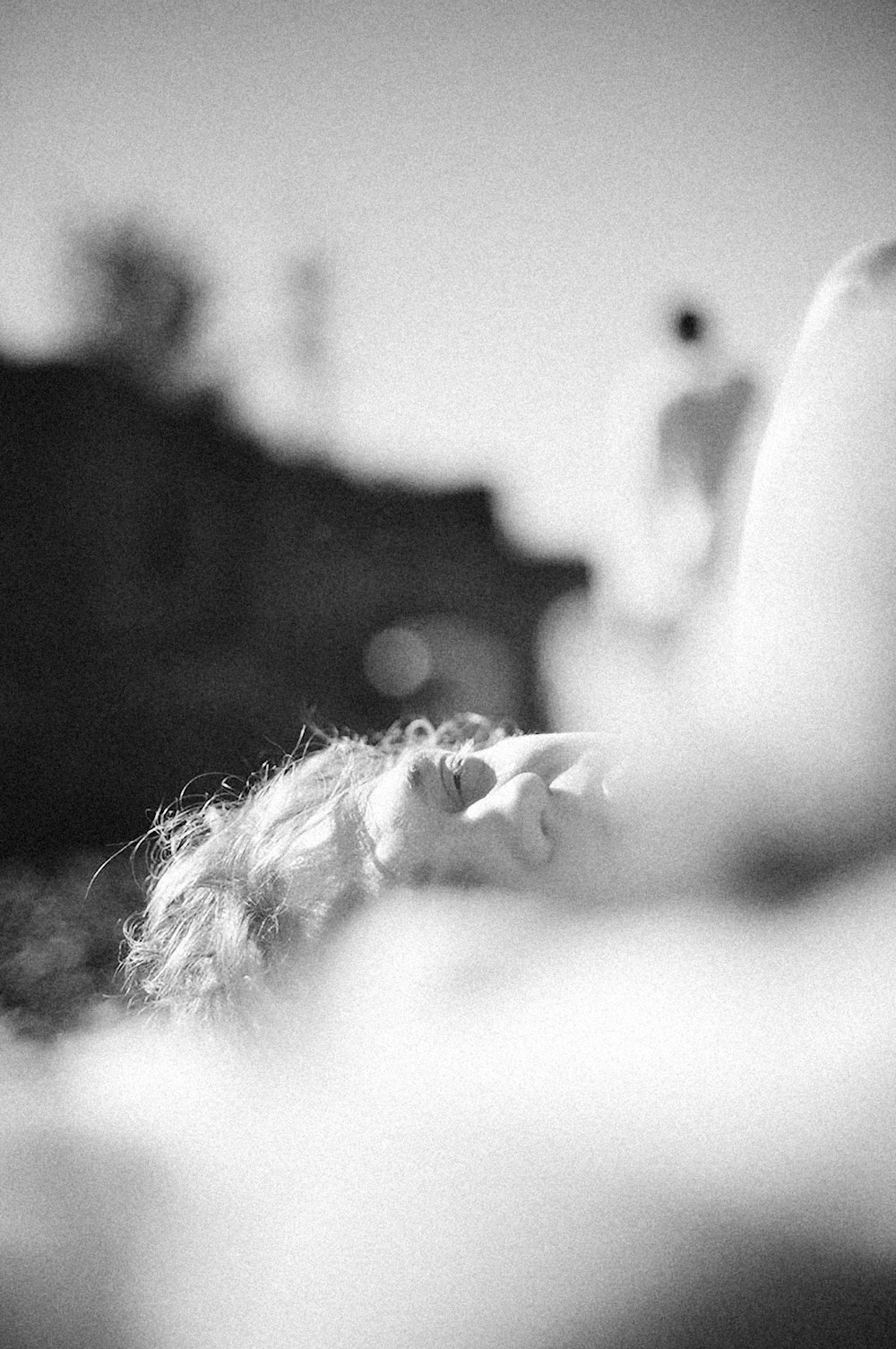 a black and white photo of a woman laying on a bed