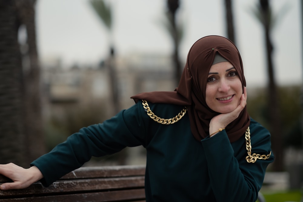 a woman in a hijab is sitting on a bench