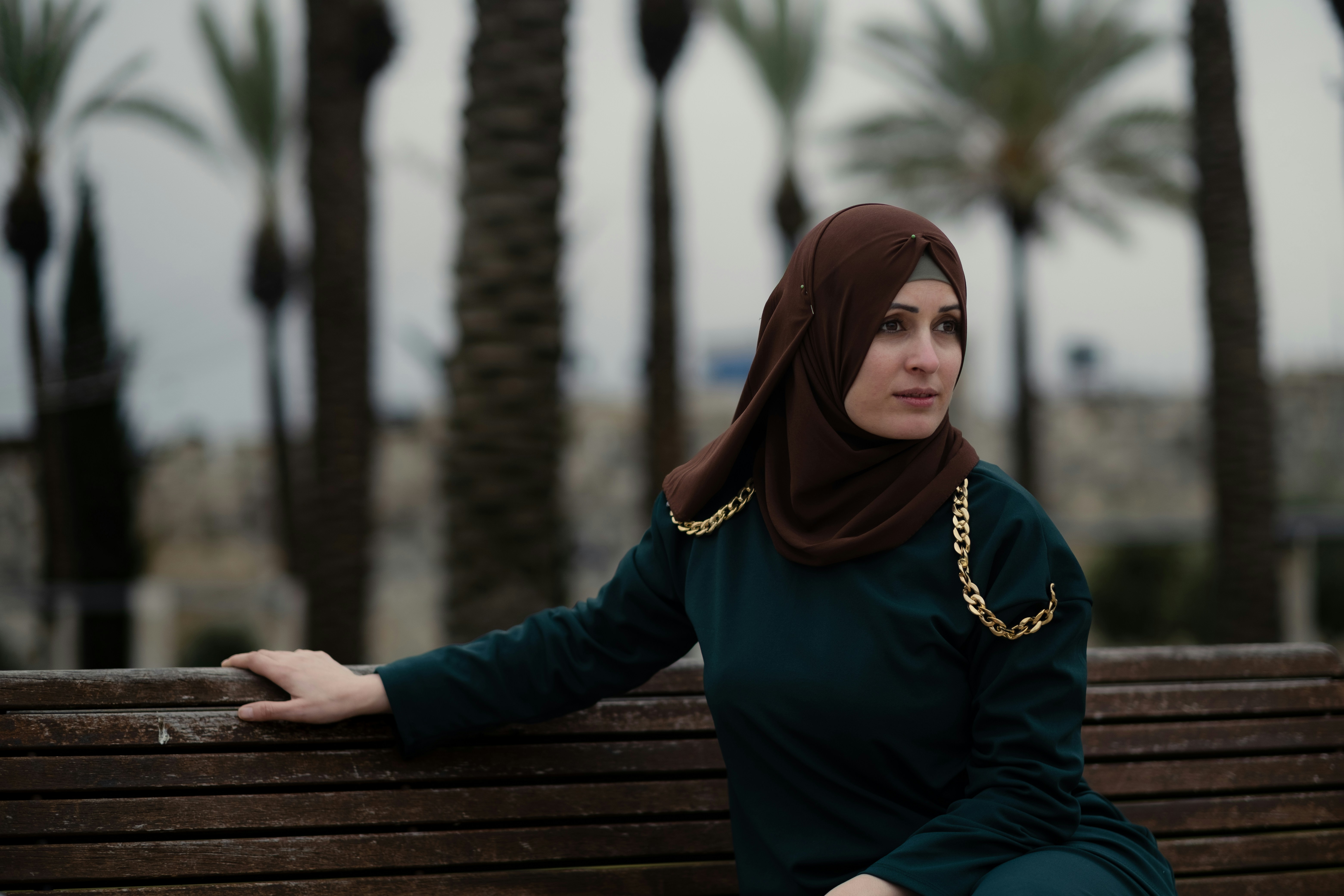 a woman in a hijab sitting on a bench, Hiba in Jerusalem.