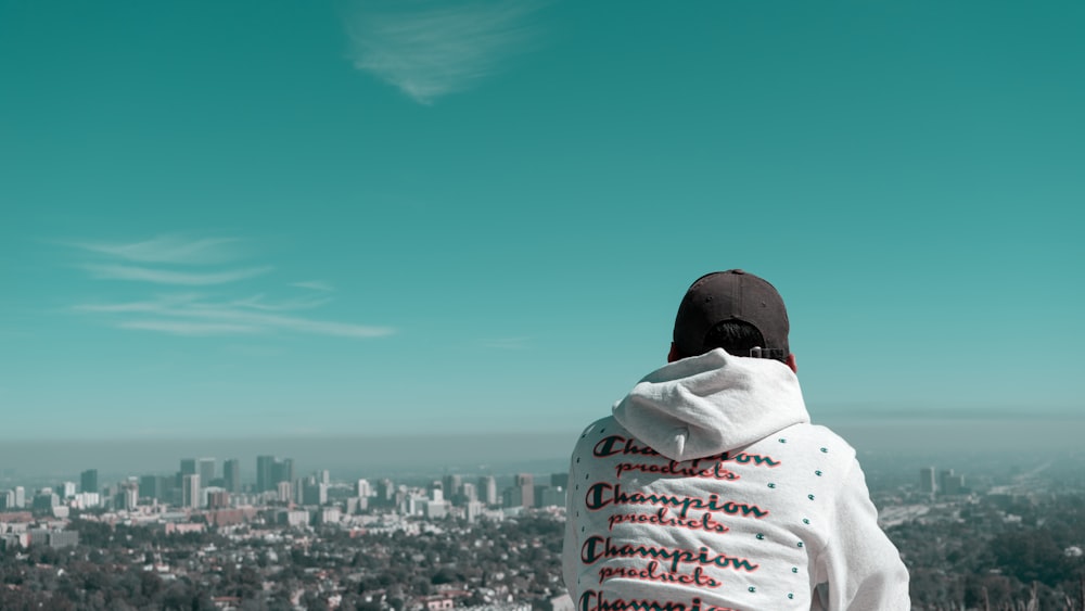 a person wearing a hoodie looking out over a city