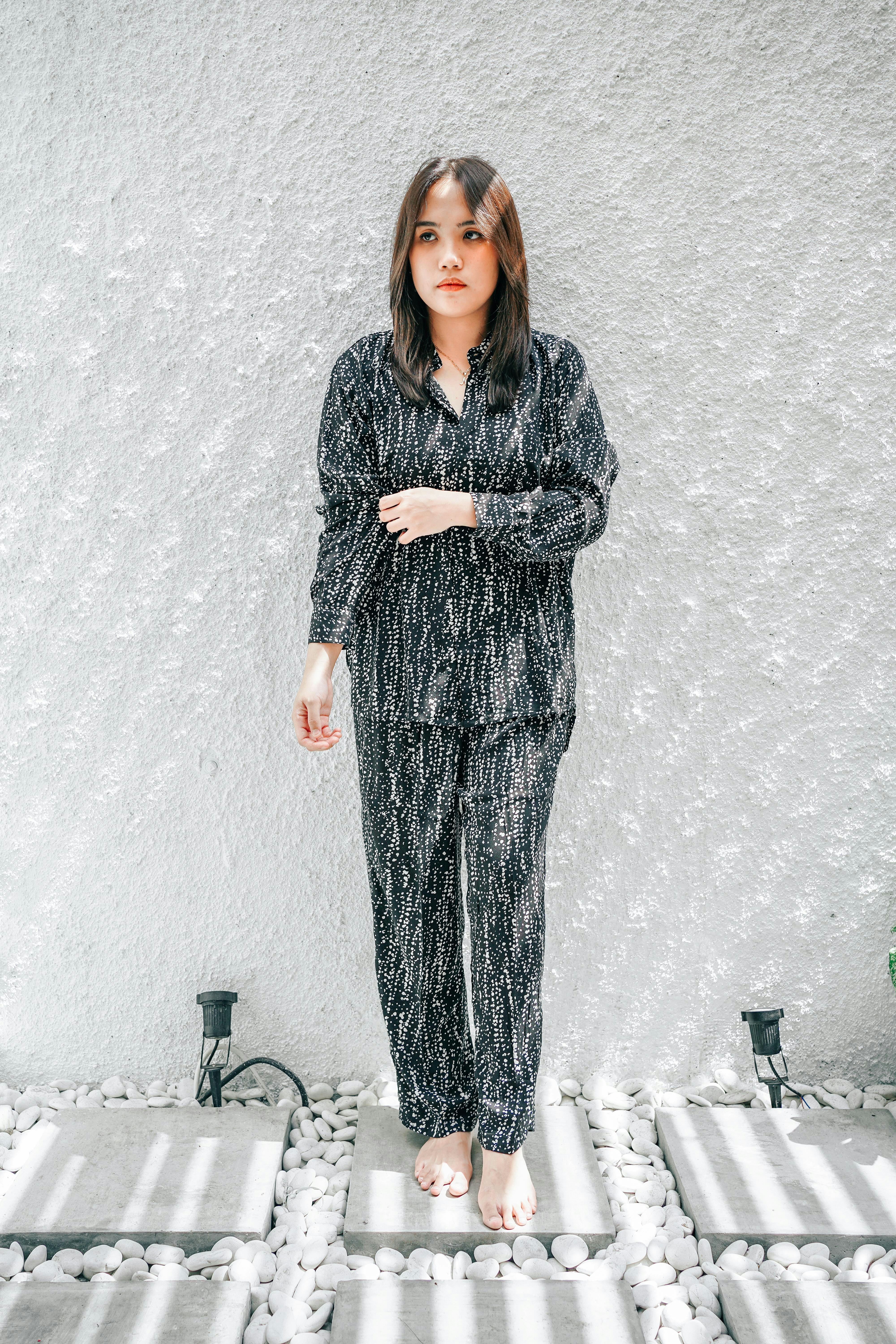 a woman standing in front of a white wall