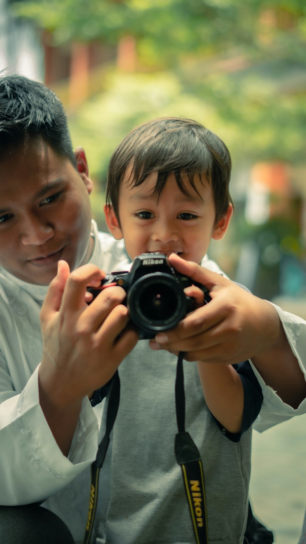 a man taking a picture of a boy with a camera