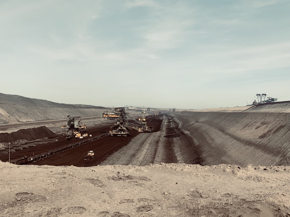 a large open pit with machinery in the middle of it