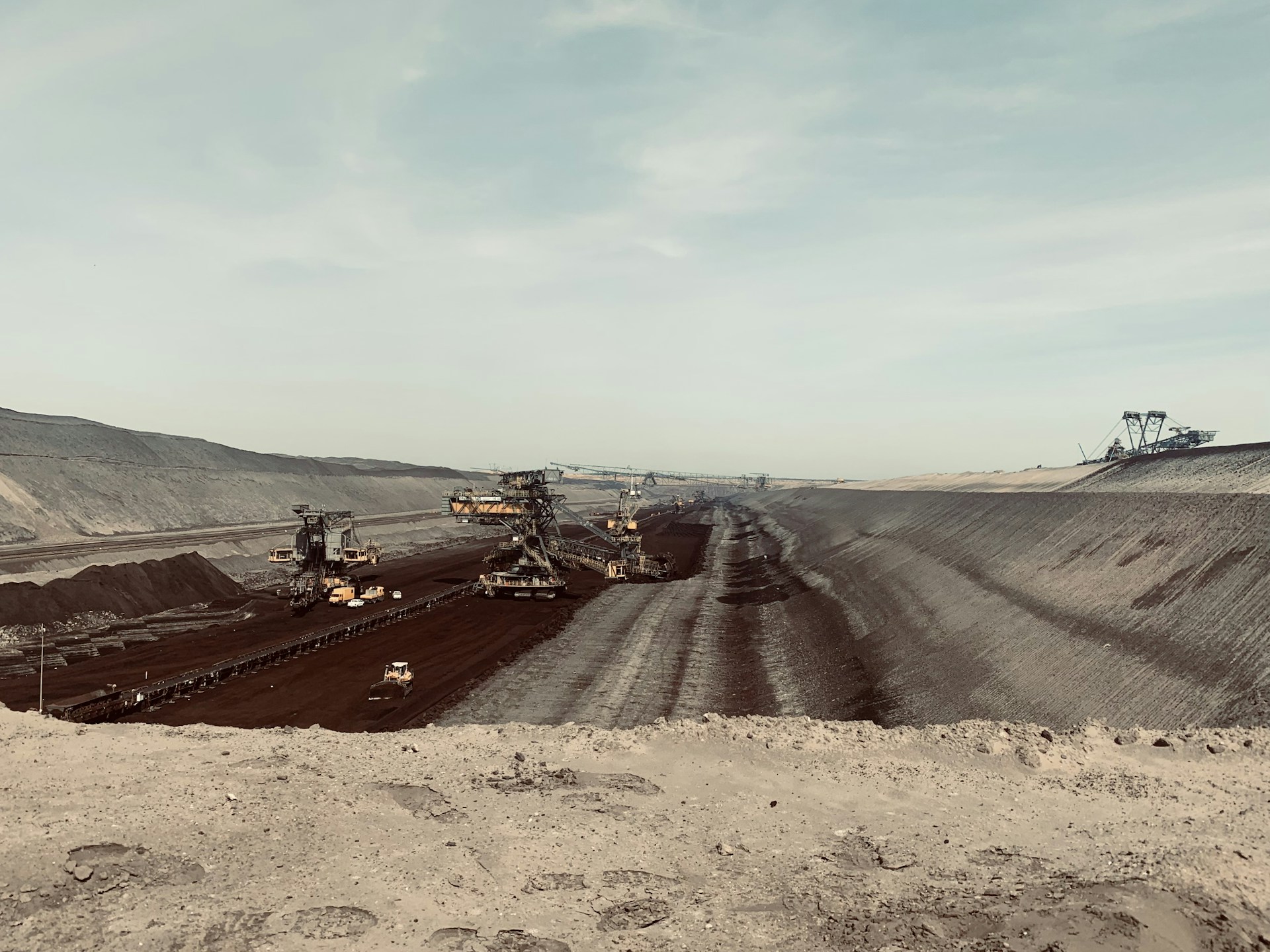 a large open pit with machinery in the middle of it
