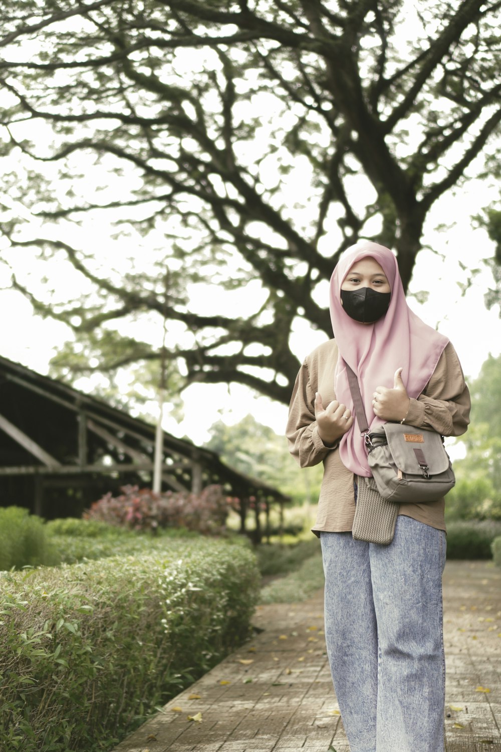 a woman in a pink scarf is standing on a sidewalk