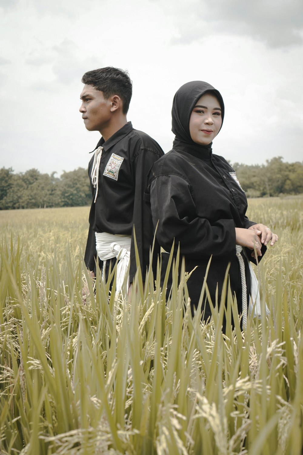two people standing in a field of tall grass