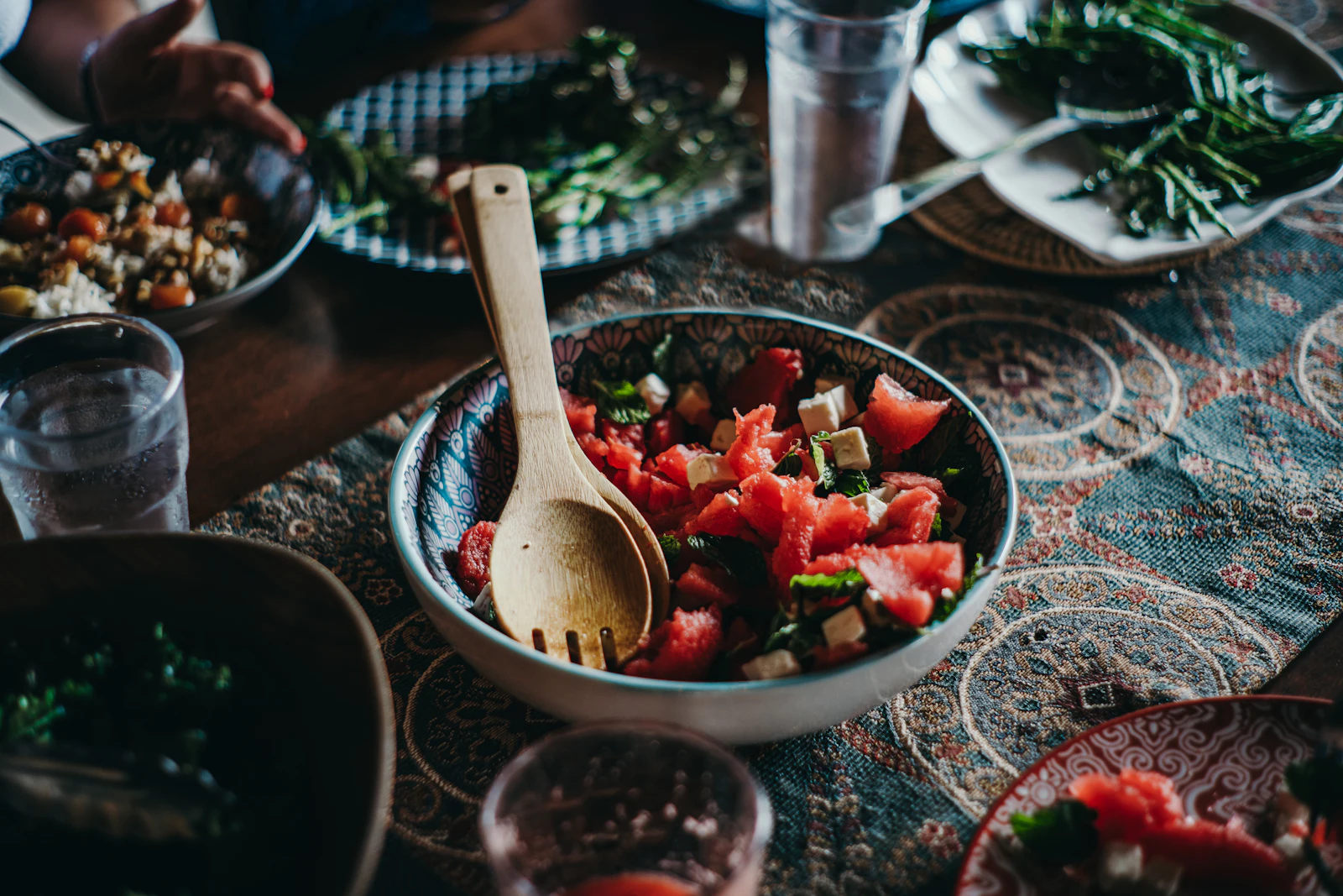 A watermelon salad with a wooden serving spoon