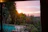 A serene view of a private pool with lush tropical garden in the background during golden hour.