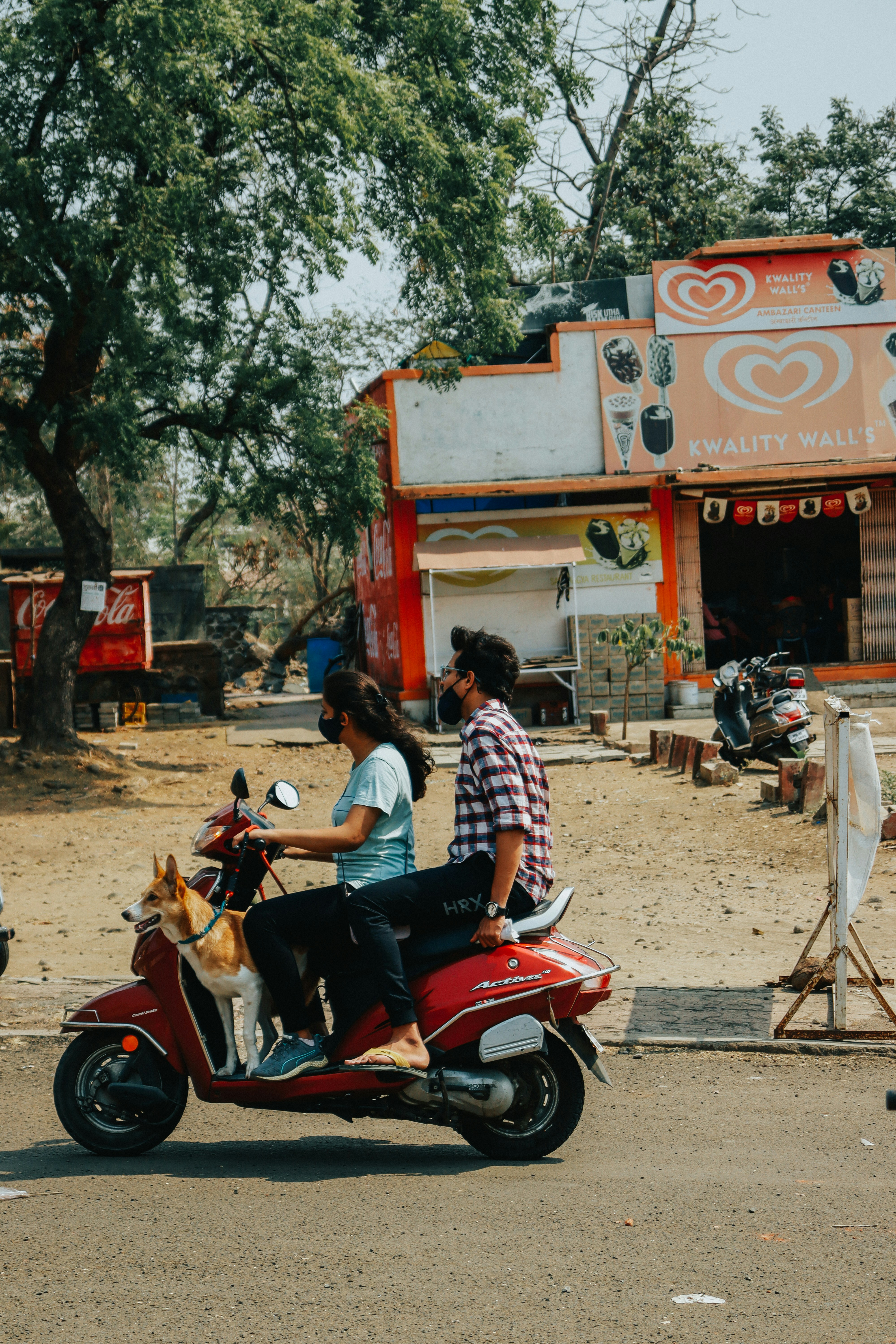 a man and a woman riding a red scooter