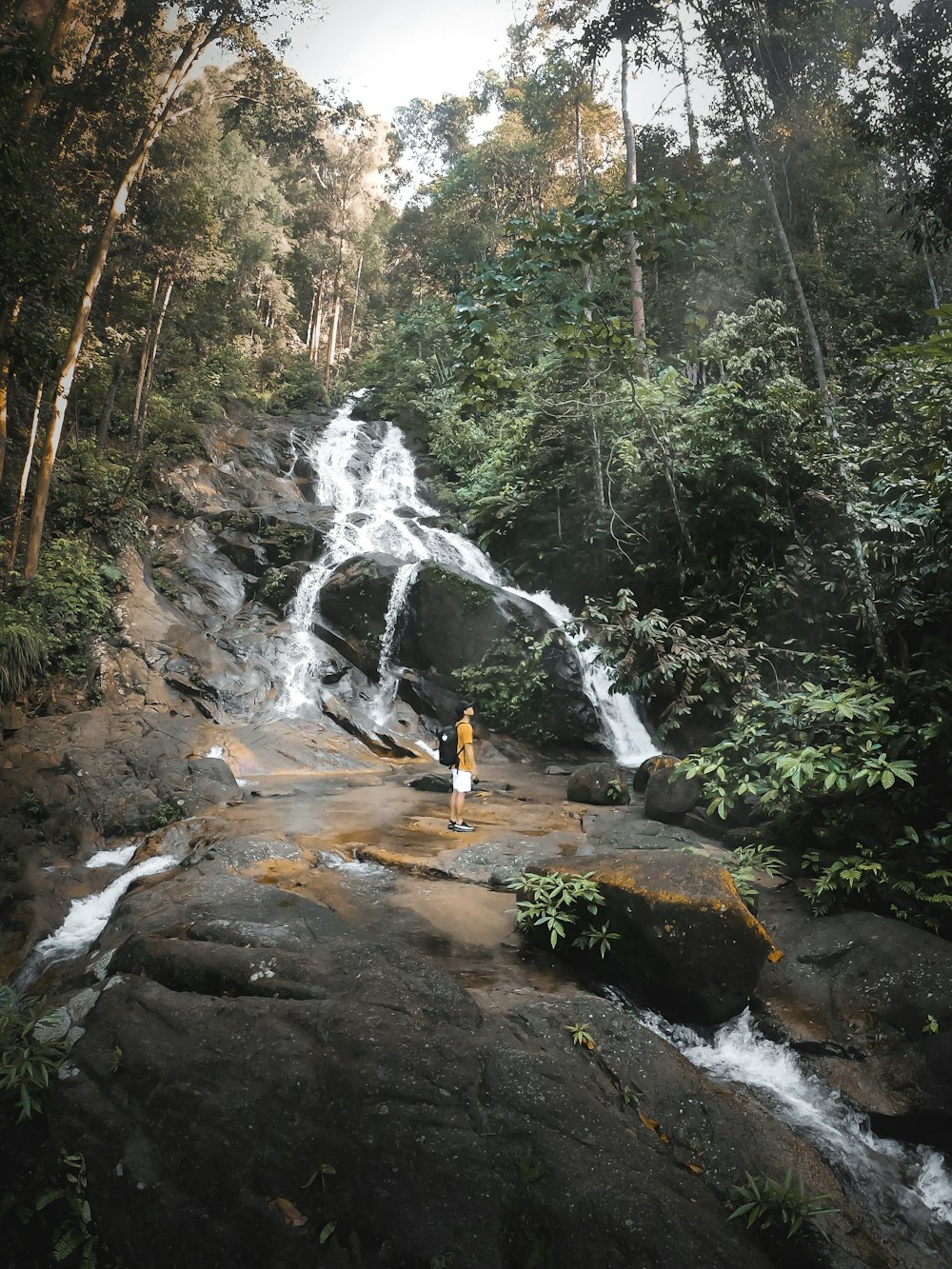 a person standing in front of a waterfall