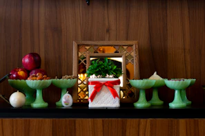 Artistic display of mirrors, vases, and red and green decorative plates on a wooden table