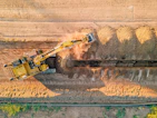 a large yellow truck driving down a dirt road