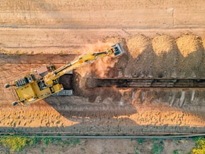 a large yellow truck driving down a dirt road