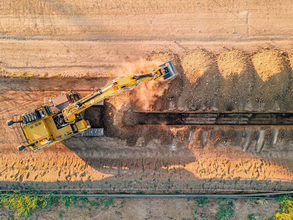 a large yellow truck driving down a dirt road