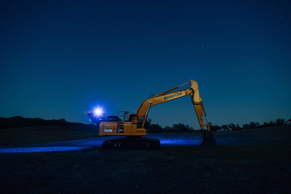 an excavator is parked in a field at night