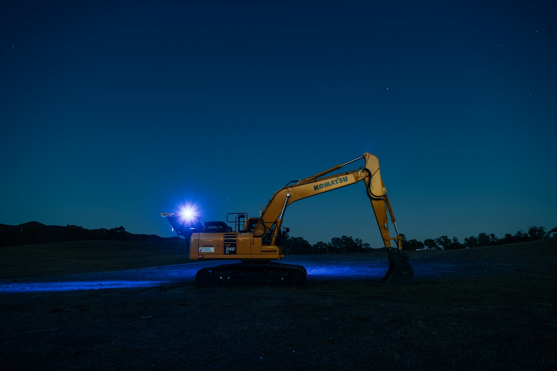 an excavator is parked in a field at night