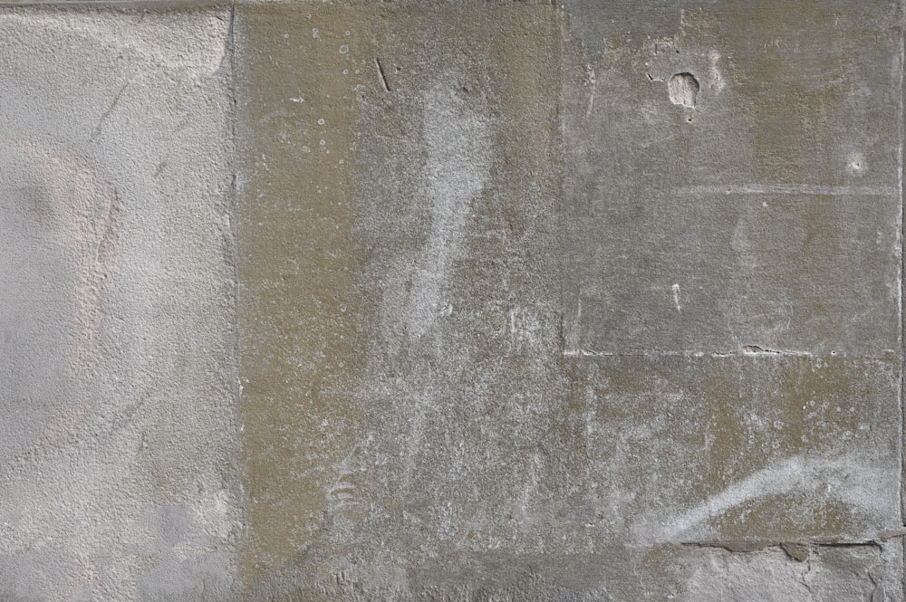 un idrante bianco seduto sul lato di un muro di cemento