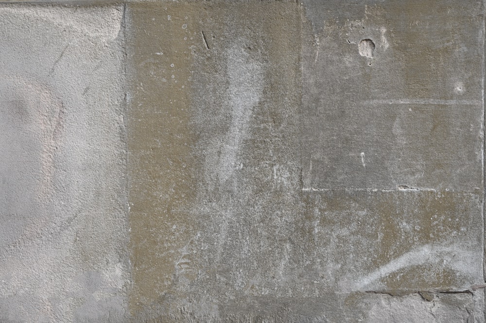 a white fire hydrant sitting on the side of a cement wall