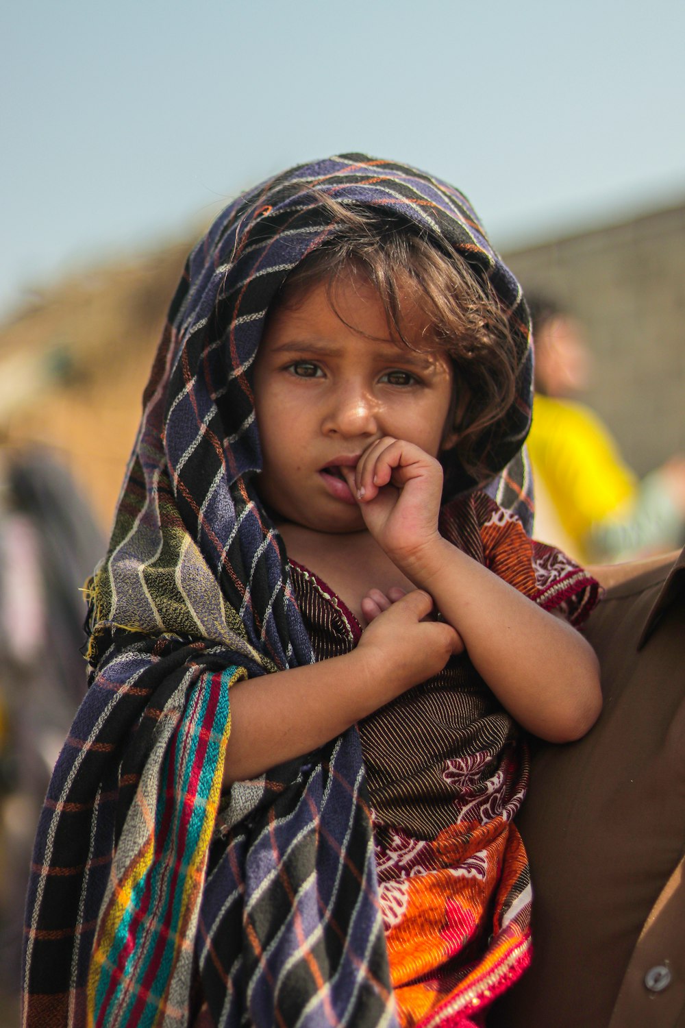 a little girl with a scarf on her head