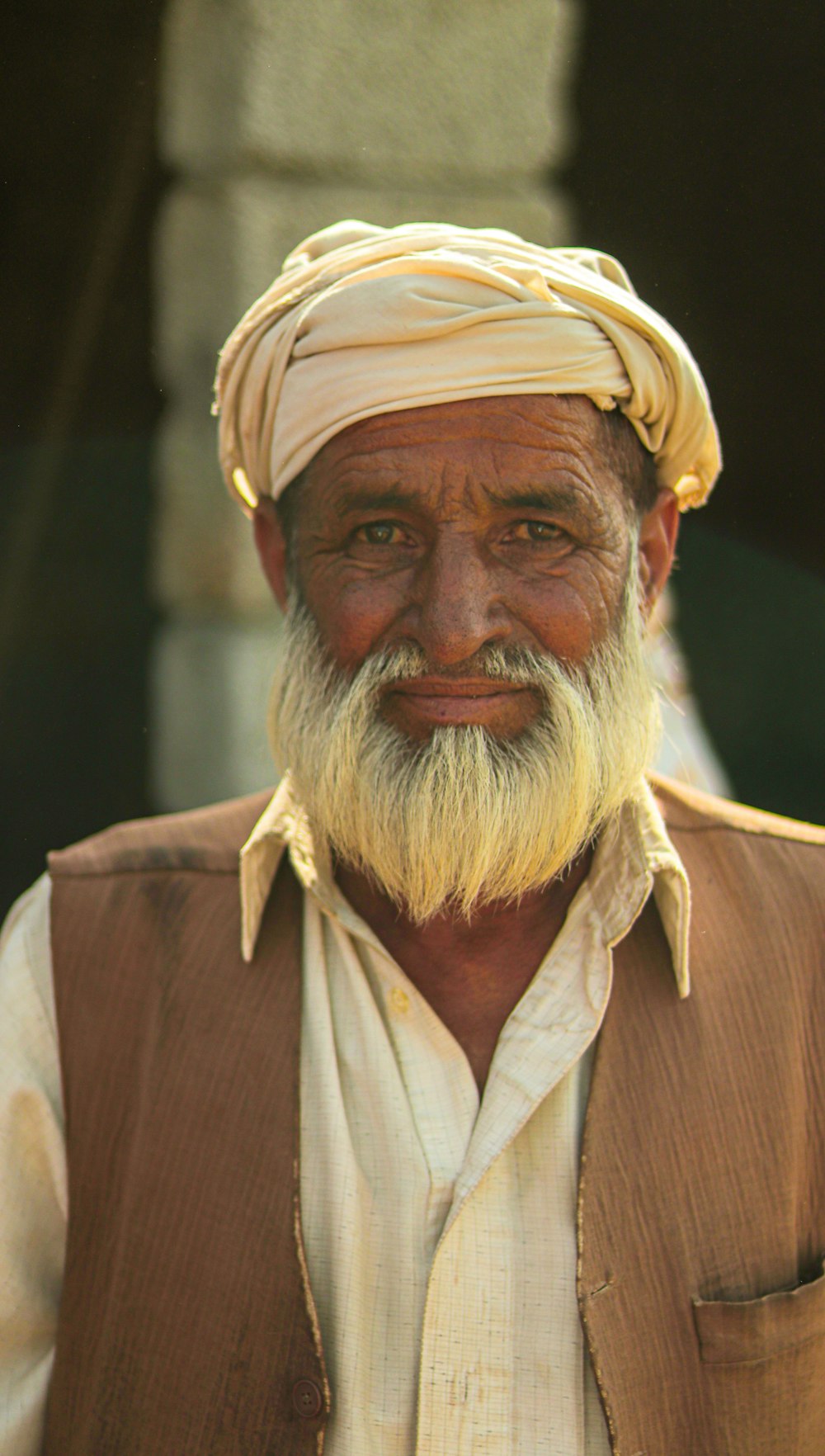 an old man with a white beard wearing a turban