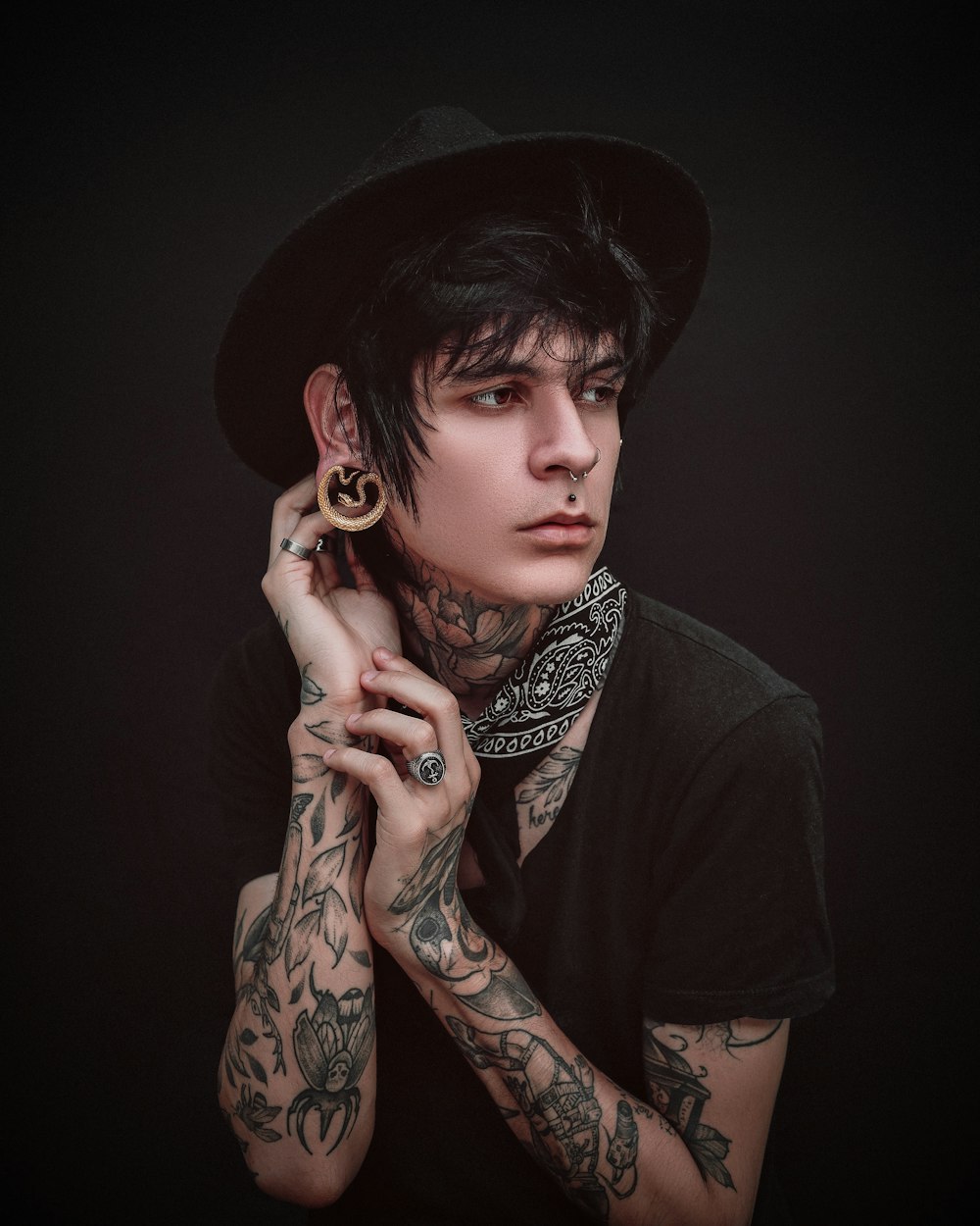 a man with tattoos wearing a black hat
