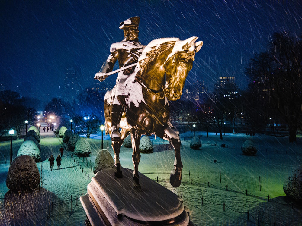 una statua di un uomo che cavalca un cavallo nella neve