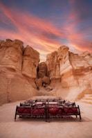 An outdoor patio with warm-toned stone flooring and built-in seating, blending seamlessly with the surrounding red rock landscape.