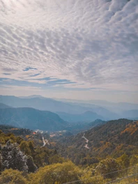 a scenic view of a valley with mountains in the background