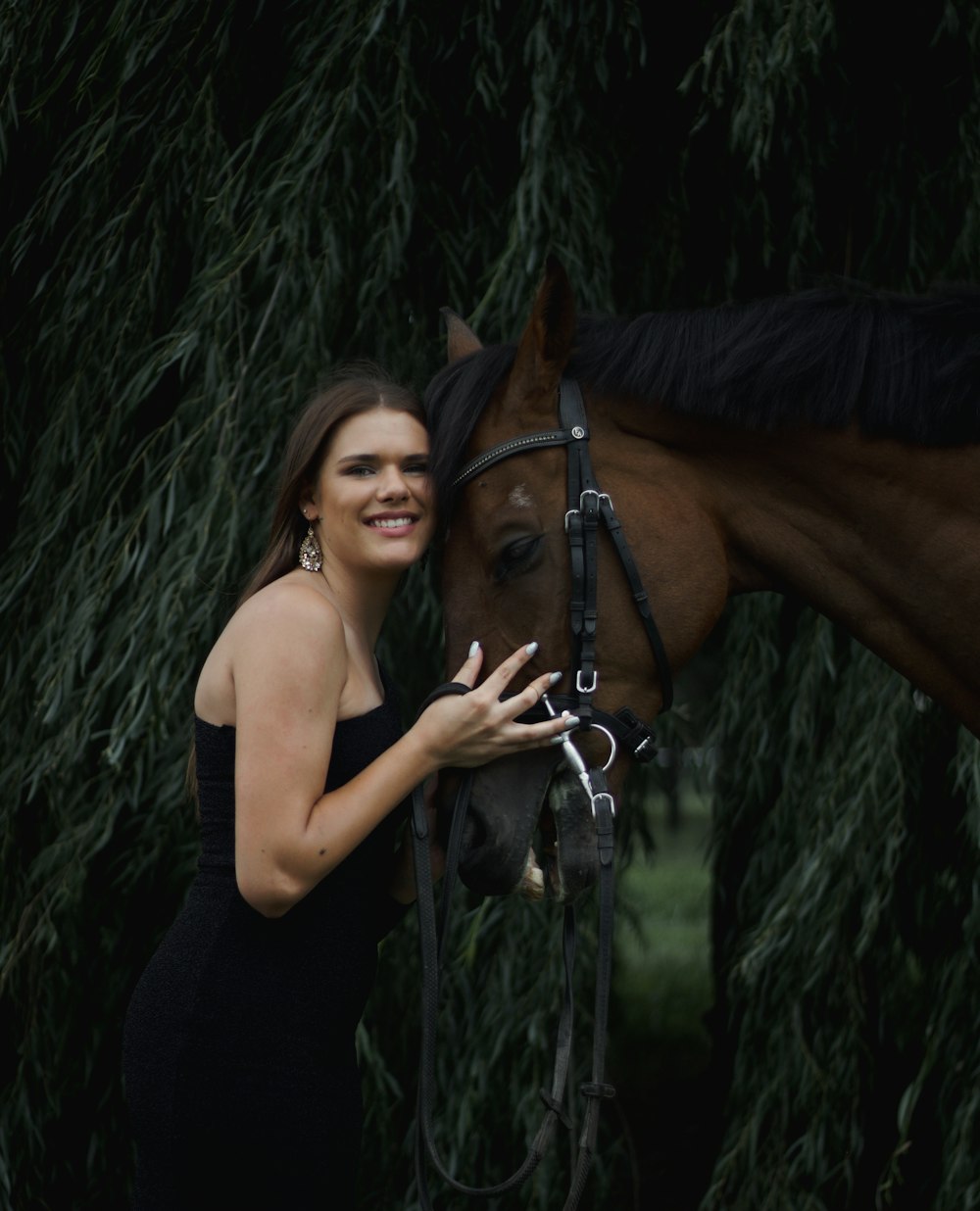 a beautiful woman standing next to a brown horse