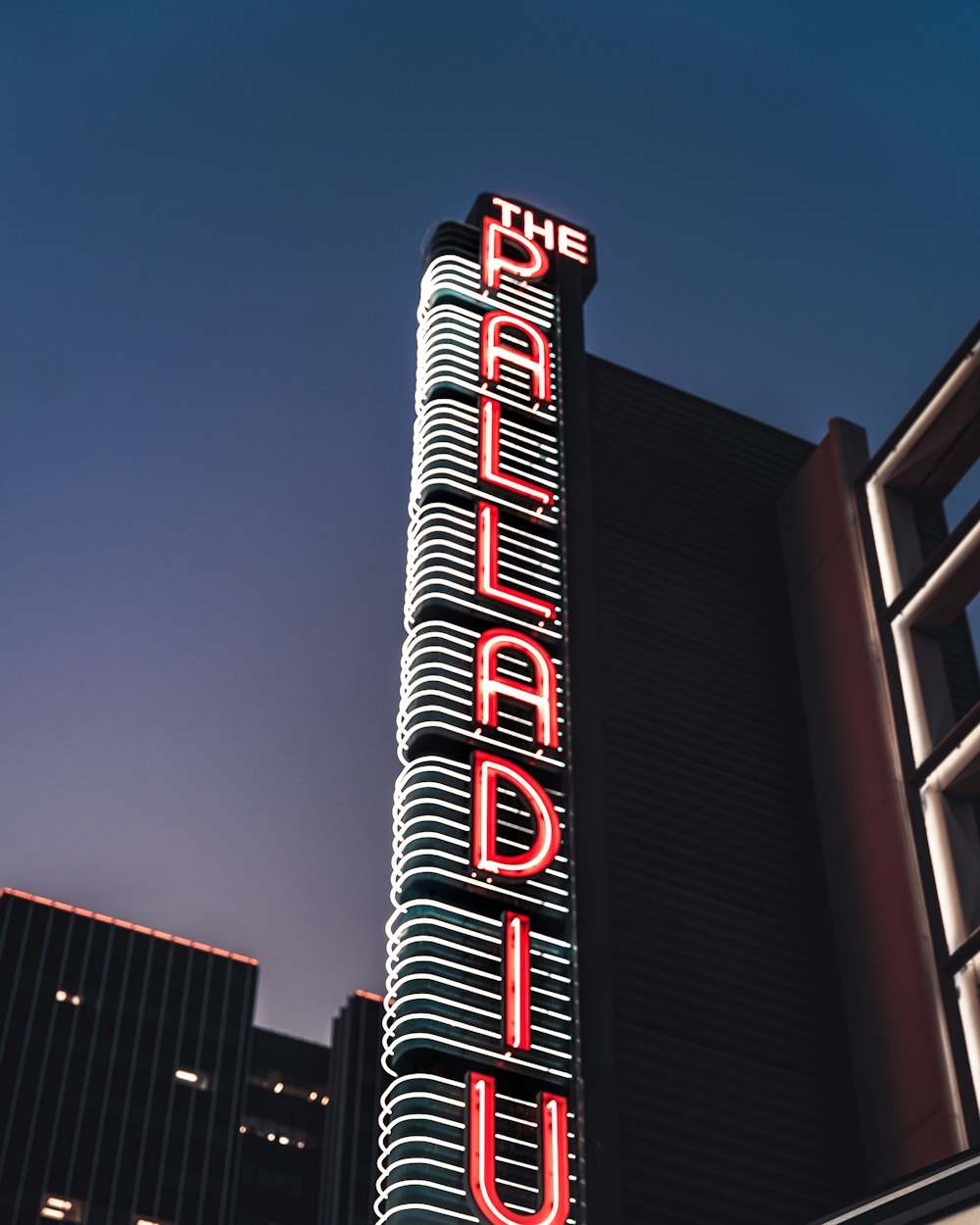 a tall building with a neon sign on it's side