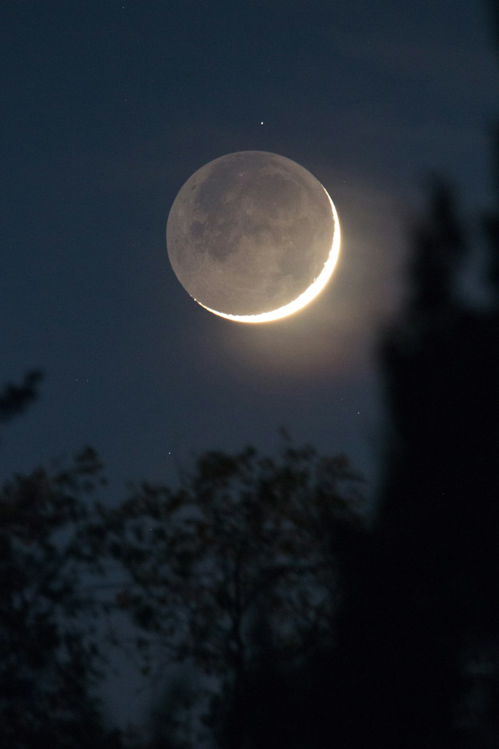 a crescent moon is seen in the night sky