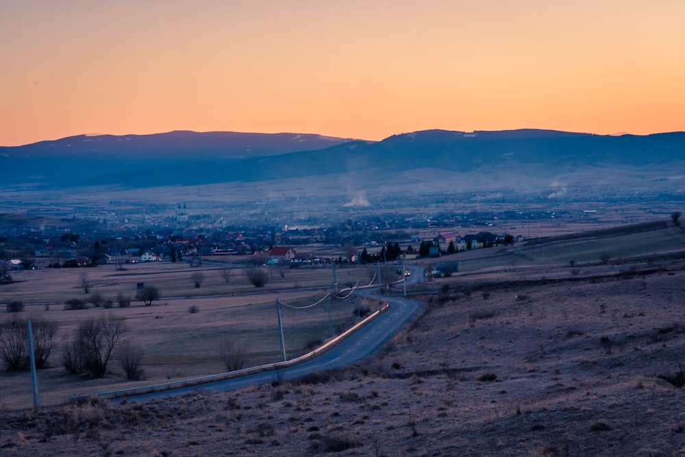 a scenic view of a rural area with mountains in the background